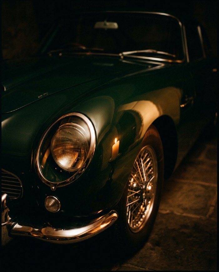 A racing-green grand tourer with chrome detail in low light